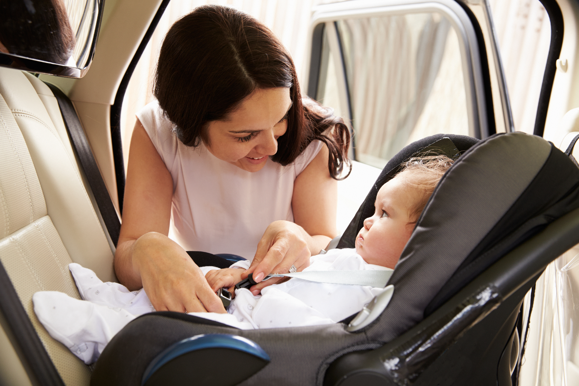Niño sentado de forma segura en una silla infantil en el asiento trasero de un coche.